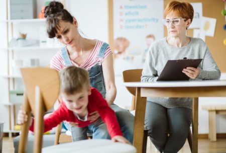 mother in denim jumpsuit helping son with adhd