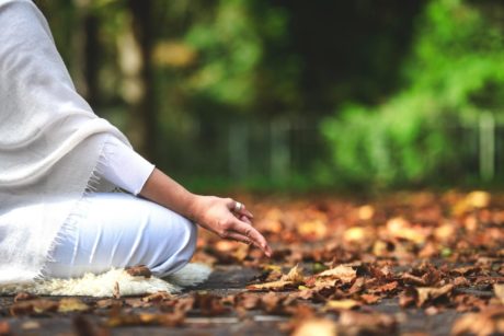 mindfulness practitioner wearing white and meditating in the woods