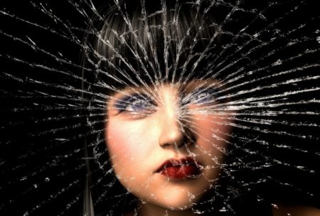 woman's face behind broken glass