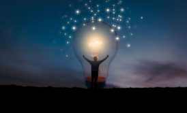 man standing inside giant light bulb