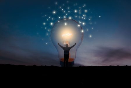 man standing inside giant light bulb