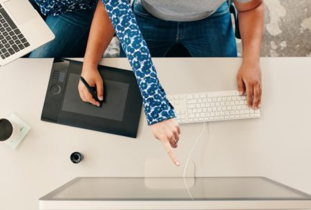 two digital illustrators working on desk