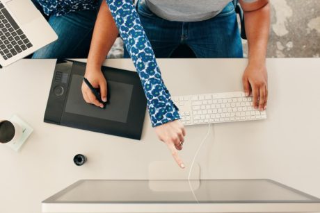 two digital illustrators working on desk