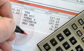 man budgeting using a balance sheet and calculator