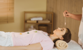 practitioner performing crystal healing on female patient