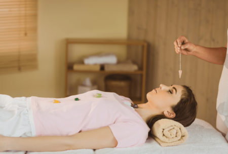 practitioner performing crystal healing on female patient