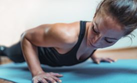 woman doing push ups on blue mat