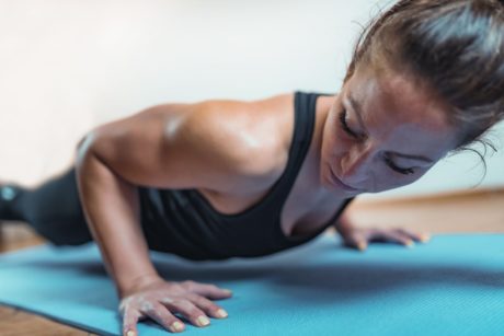 woman doing push ups on blue mat