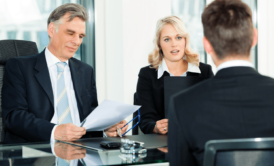 ceo and hiring manager interviewing a male job applicant in black suit