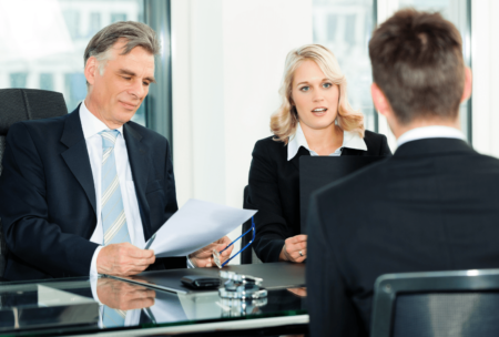 ceo and hiring manager interviewing a male job applicant in black suit