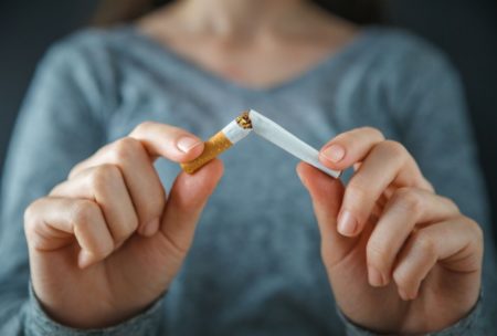 woman breaking a cigarette in two with her hands