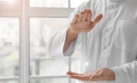 Hands of reiki practitioner wearing white