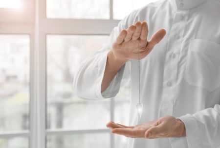 Hands of reiki practitioner wearing white