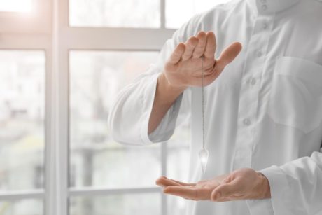 Hands of reiki practitioner wearing white