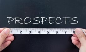 person measuring the word prospects written on chalkboard