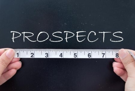 person measuring the word prospects written on chalkboard