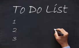man writing to do list on chalkboard