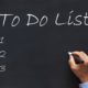 man writing to do list on chalkboard