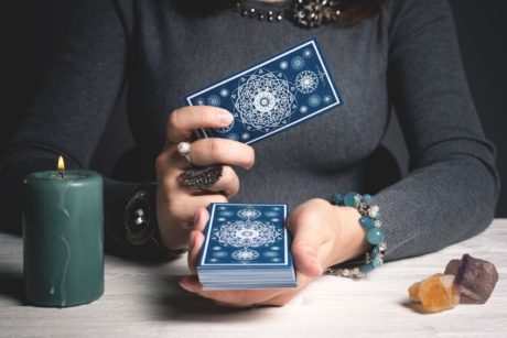 tarot card reader holding deck of cards