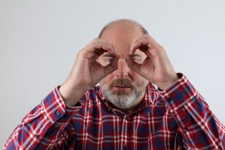 man holding hands like binoculars looking for freelance copywriting work