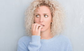 woman with anxiety biting her nails