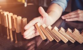 agile manager stopping a pile of wooden blocks from falling