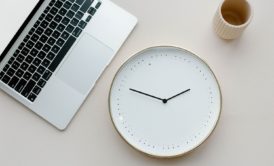 clock cup and silver laptop