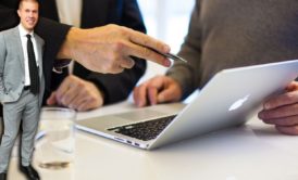 business consultant talking to client pointing at silver laptop