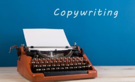 typewriter against blue background copywriting