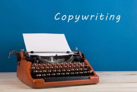 typewriter against blue background copywriting