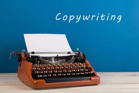 typewriter against blue background copywriting