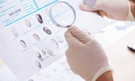 criminologist examining fingerprint profile