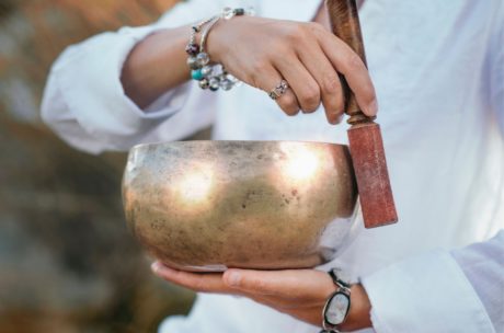 a person gently holds a singing bowl, symbolizing sound healing and relaxation