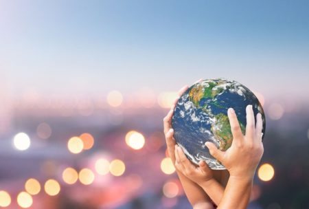 hands gently holding the earth, symbolizing sustainable tourism and the importance of protecting our planet on earth day