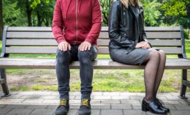 man and woman sitting on park bench