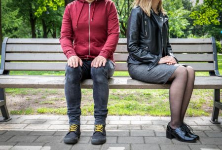 man and woman sitting on park bench