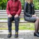 man and woman sitting on park bench