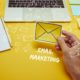 person holding yellow envelope with title email marketing