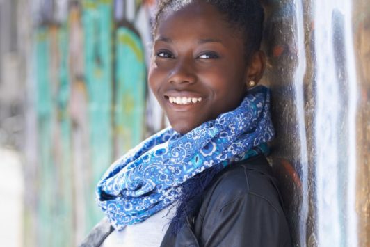 smiling woman in jacket and blue scarf