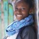 smiling woman in jacket and blue scarf