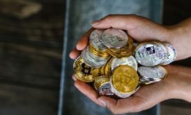 hands holding a bunch of crypto coins