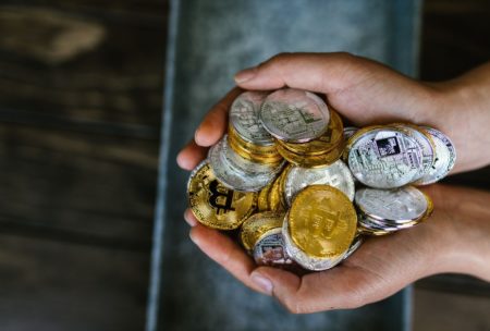 hands holding a bunch of crypto coins