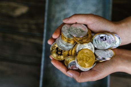 hands holding a bunch of crypto coins