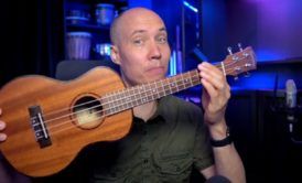 a man holding a ukulele demonstrating learn how to play ukulele