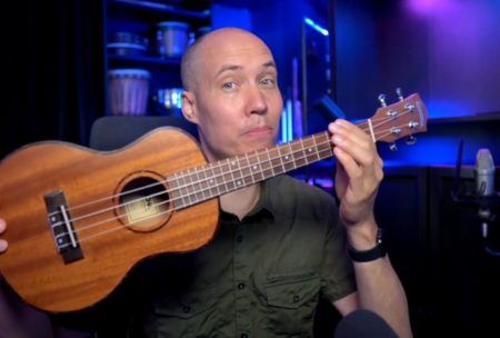 a man holding a ukulele demonstrating learn how to play ukulele