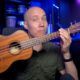 a man holding a ukulele demonstrating learn how to play ukulele