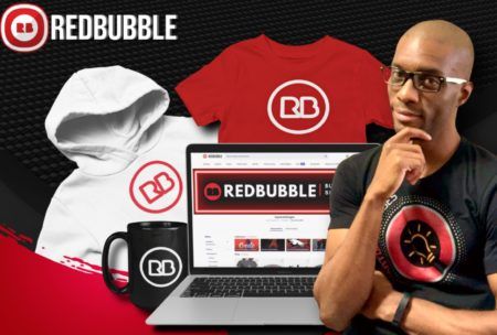 a laptop displaying Redbubble course, surrounded by various clothing items like t-shirts and hoodies