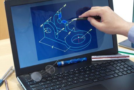 person using laptop to draw on blueprint while taking introduction to finite element analysis course