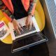 a person sitting on a yellow chair with a laptop, studying the best course in python