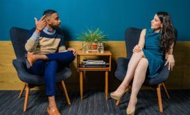 a man and woman discussing how to become a social worker while sitting in chairs